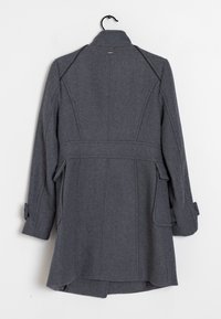 Grå uldfrakke med skræddersyet design, lange ærmer og bælte i taljen. Har sidelommer og høj krave.