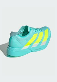 Turquoise athletic shoe with neon yellow stripes, textured upper, cushioned heel, and Lightstrike Pro branding on the midsole.