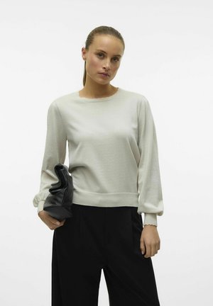 Pullover grigio chiaro a maniche lunghe con finitura testurizzata, scollatura a ondine e polsini arricciati. Il modello tiene una pochette nera.