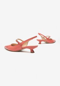 Chaussures slingback en cuir verni corail avec un bout pointu, une boucle réglable et un petit talon carré. Texture lisse avec un minimum de détails.