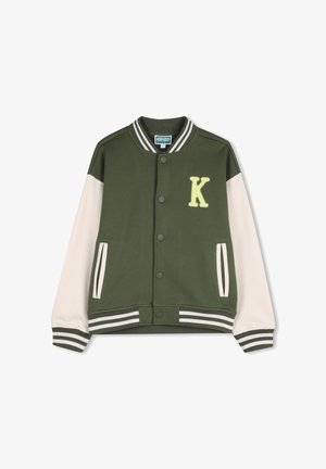 Groene varsityjas met crèmekleurige mouwen, geribbelde manchetten en zoom, met een gele 'K' patch op de borst en drukknoopsluiting.