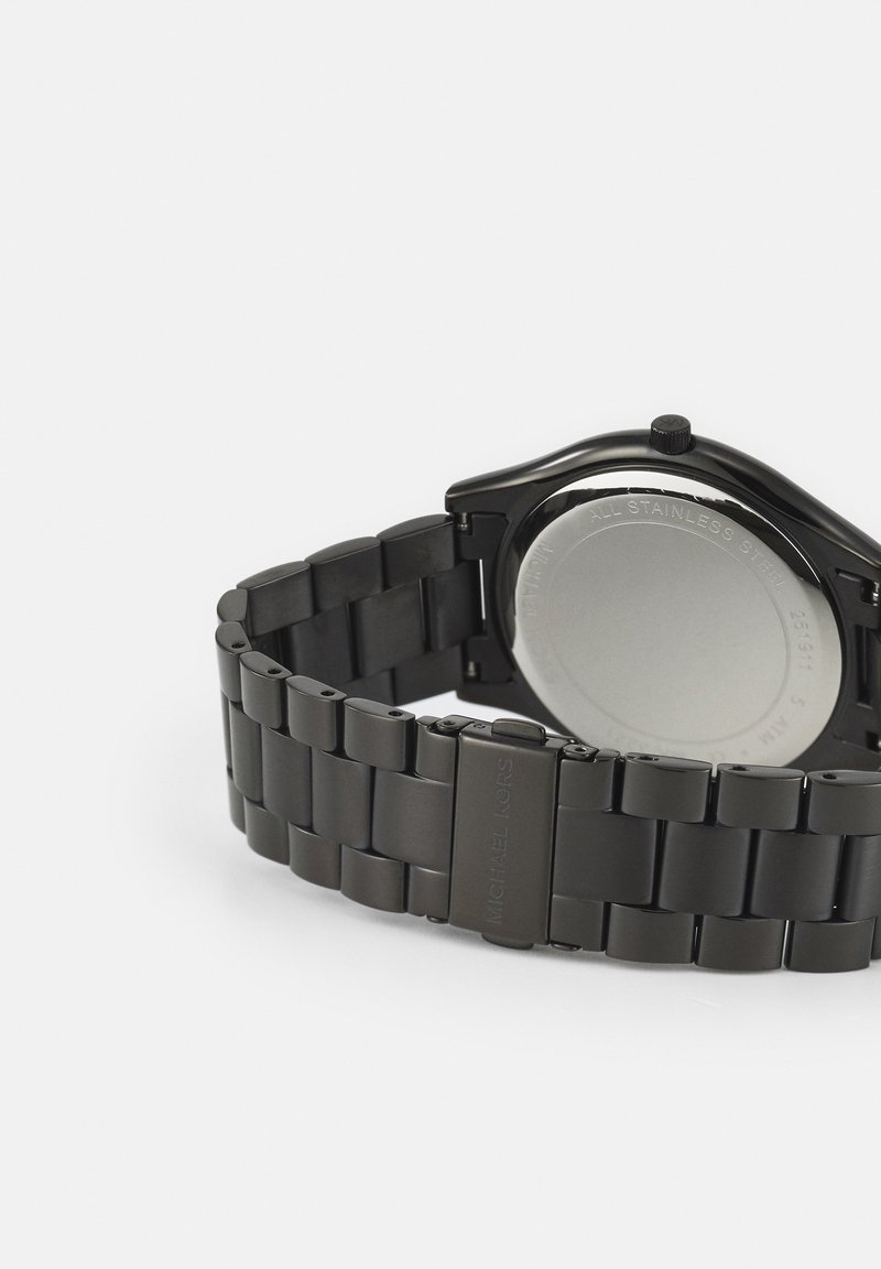 Reloj de pulsera de acero inoxidable negro con brazalete enlazado, cierre cerrado y parte trasera metálica visible con texto grabado.