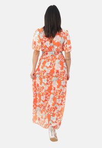 Robe maxi à imprimé floral orange avec des manches bouffantes, une taille cintrée et un dos en V profond. Tissu léger et fluide.