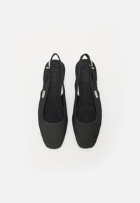 Sapatilhas slingback pretas de tecido com uma palmilha de camurça suave. O design apresenta uma bico arredondado e um brilho subtil no material superior.