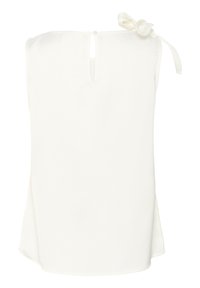 Blouse blanche sans manches avec un dos en forme de clé, tissu doux, et un détail de nœud à l'épaule gauche. Texture lisse et coupe décontractée.