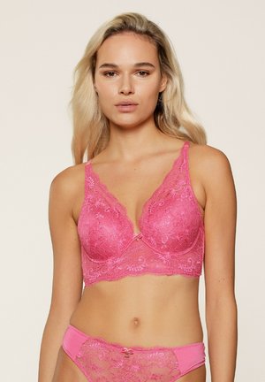 Roze kanten beha met geborduurde bloemenpatronen, diepe halslijn, verstelbare banden en een decoratieve strik in het midden.