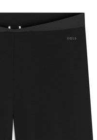 Zwarte high-waist leggings met een brede tailleband en een klein "BOSS" logo op de linker heup.
