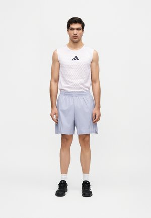 Homme debout face à l’avant portant un maillot blanc sans manches Adidas, un short de sport bleu clair, des chaussettes blanches et des baskets noires.