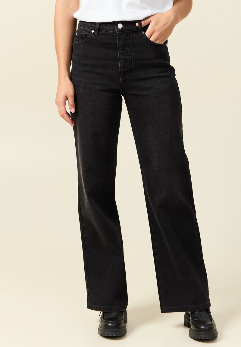 Pantalones vaqueros de pierna ancha de cintura alta en negro, hechos de mezclilla, con diseño de cinco bolsillos, herrajes plateados y una ligera textura para mayor durabilidad.