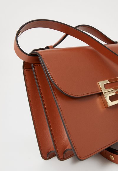 Bolso de cuero marrón con cierre de solapa y un broche de hardware dorado, que cuenta con una correa larga y detalles de costura visibles.