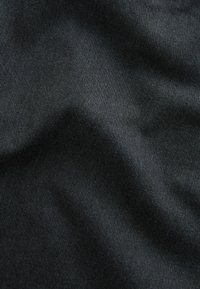 Schwarzer Stoff mit glatter, leicht glänzender Textur, der subtile Falten und Farbvariationen aufweist, was auf seine Weichheit und sein Gewicht hinweist.