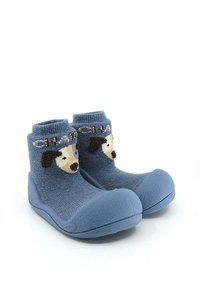 Calcetines de lana azules con un diseño de perro en el tobillo exterior, que cuentan con una suela de goma y una parte superior texturizada para un mejor agarre.