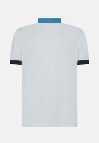 Polo a maniche corte di colore azzurro chiaro con colletto blu strutturato e polsini neri. Tessuto morbido, design classico della polo, senza motivi visibili.