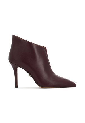 Stivale alla caviglia in pelle bordeaux con punta affusolata, tacco a stiletto e texture liscia. Presenta un design con taglio laterale per un tocco di dettaglio in più.