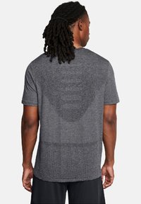 Gray short-sleeve athletic shirt made of breathable fabric, featuring a relaxed fit and smooth texture with a subtle pattern on the back.