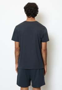 Mørkegrå bomulds t-shirt til mænd med korte ærmer og lige kant, parret med matchende shorts. Glat tekstur, enkelt design.