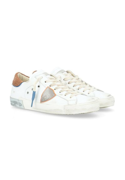 Sneakers bianchi con accenti beige, tallone marrone testurizzato, dettagli del logo argento e arancione, e lacci crema, con leggeri segni di usura e sporco.
