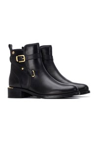 Botas negras de cuero hasta el tobillo con puntera redondeada, hebilla lateral y acentos dorados. Presentan un tacón bajo y suela texturizada.