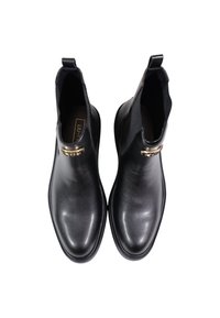 Bottines en cuir noir avec une texture lisse, des panneaux latéraux élastiques et un accent décoratif en or près de la cheville. Design à bout arrondi.