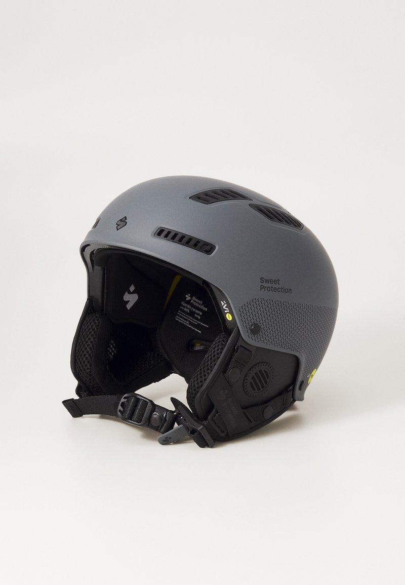 Gray ski helmet with vent holes, textured sides, and adjustable strap. Features branding and interior padding for comfort and protection.