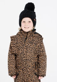 Bruine jas met luipaardprint, met gerimpelde schouders, zwarte afwerking en een volledige rits. Gecombineerd met een zwarte gebreide beanie met een pompon.