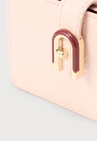 Geantă roz din piele cu finisaj texturat, prevăzută cu un detaliu de închidere din metal auriu și bordo și colțuri rotunjite.