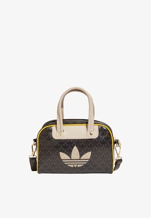 Mała brązowa torebka z beżowymi uchwytami, żółtym obszyciem i dużym jasnobeżowym logo Adidas trefoil na przednim panelu.