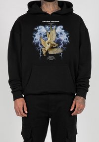Black hoodie featuring a graphic of two doves against a stormy blue background with lightning. Includes a front pocket and ribbed cuffs.