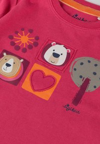 Rosa Baumwoll-T-Shirt mit Tiermotiven und einem Herzdesign. Die Grafiken zeigen einen Bären, einen lächelnden Eisbären und einen gemusterten Baum.