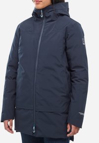 Veste d'extérieur bleu marine en tissu résistant �à l'eau, dotée d'une fermeture éclair à l'avant, d'une capuche ajustable et d'un détail de logo sur la manche.