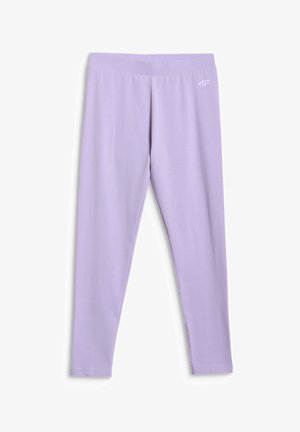 Fille aux longs cheveux bruns portant un bonnet rose, une chemise beige, un sweat rose noué autour de la taille, des leggings lavande, des chaussettes blanches et des baskets blanches.