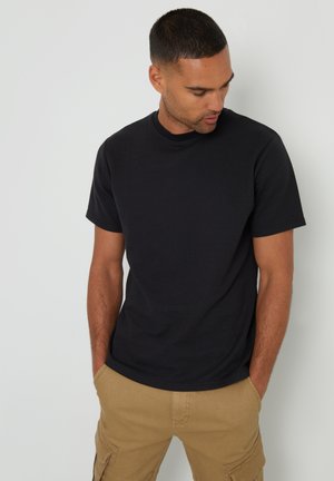 Schwarzes Rundhals-T-Shirt aus Baumwolle, mit kurzen Ärmeln und lockerem Schnitt, getragen mit khakifarbenen Cargo-Shorts. Einfaches, klassisches Design.