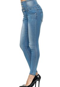 Jeans ajustados de tiro alto en denim azul claro. Cuenta con cierre de cinco botones, bolsillos frontales y una textura ligeramente desgastada.