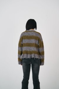 Csíkos pulóver szürke és olíva zöld színben, puha, bolyhos anyagból készült. Laza szabású, rojtos aljjal és hosszú ujjakkal rendelkezik.