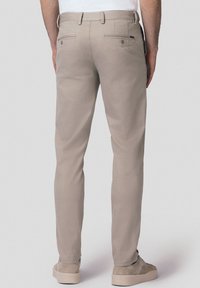 Jasnoszare spodnie o prostym kroju, z tylnymi kieszeniami na guziki i gładką fakturą; w zestawieniu z jasnoszarymi butami.