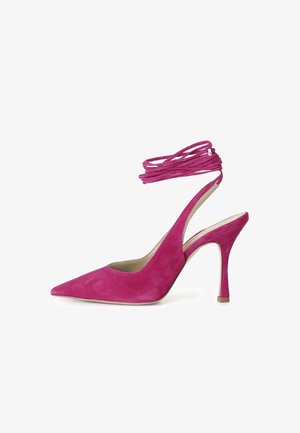 Chaussure à talons hauts en suede rose, avec un bout pointu, des liens à la cheville et un talon aiguille effilé. Texture lisse et design minimaliste.