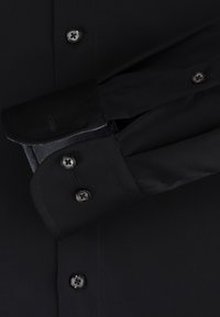 Zwarte dress shirt met een button-down kraag, grijs patroon op de manchetten, zwarte knopen en een gladde textuur.