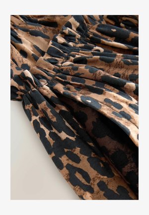 Leopardenmusterstoff in Braun und Schwarz mit geraffter Textur, sichtbaren Nähten und weicher, glatter Oberfläche.