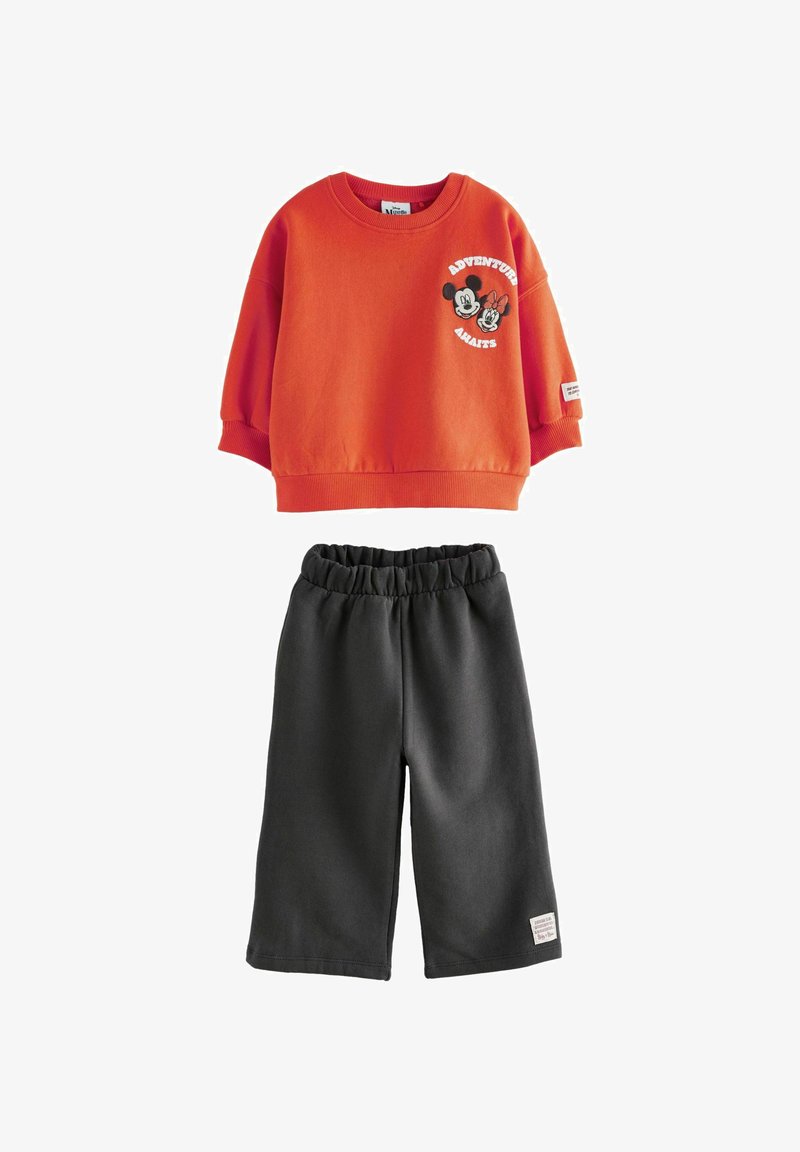 Orange sweatshirt with graphic text and characters, paired with dark gray shorts. Both made from soft, stretchy fabric with elastic waistband.