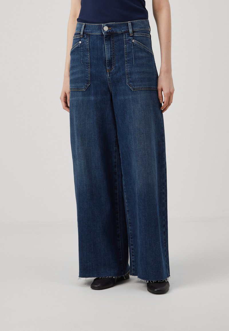 Široke traperice u tamnoplavoj boji, s dva prednja džepa, zatvaranjem na dugme i detaljima rastrganih rubova. Glatka tekstura i ležeran dizajn.