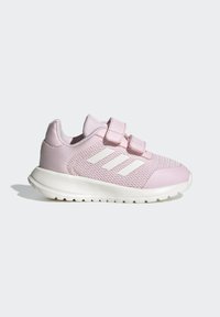 Zapatillas deportivas rosas con parte superior de malla y sintética, dos correas de Velcro, suela blanca y tres rayas diagonales blancas en el lateral.