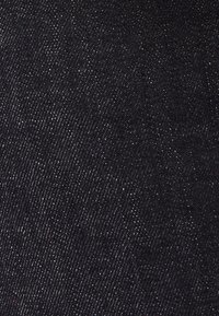 Tejido de mezclilla negra con una textura suave, que presenta un ligero brillo y un patrón de tejido de espiga diagonal, creando un aspecto elegante y sólido.