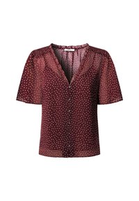 Blouse mauve à pois avec manches courtes bouffantes, encolure en V et fermeture boutonnée à l'avant. Confectionnée dans un tissu léger et transparent, agrémentée de volants.