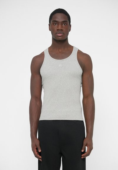 Grå tanktop af bomuldsblanding, med rund halsudskæring og uden ærmer, båret af en model mod en ensfarvet baggrund.