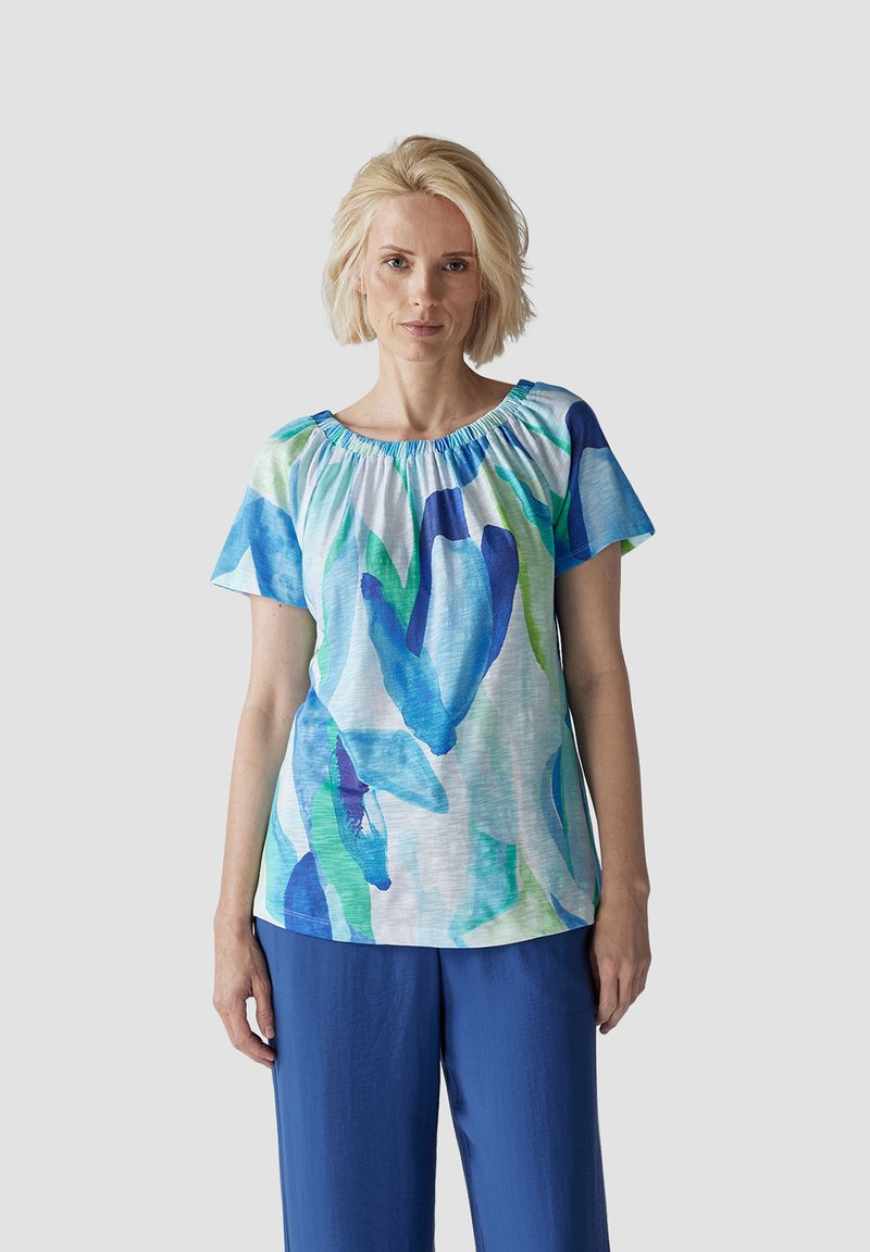 Short-sleeve top with a gathered neckline, featuring a blue and green floral pattern on a light background. Made of lightweight fabric.
