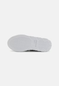 White rubber sneaker sole with textured grip patterns. Imprinted "LOVE MOSCHINO" near the center. Smooth surface with subtle ridges.