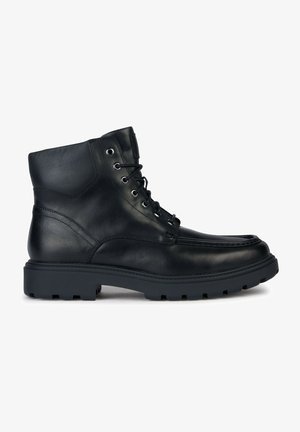 Czarne skórzane botki za kostkę z okrągłym noskiem, sznurowane z przodu i z wytrzymałą podeszwą. Oferują srebrne oczka, detal szycia oraz teksturowane wykończenie.