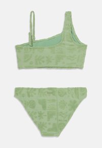 Grünes Frottee-Bikini-Set mit einem Cropped Top und verstellbarem Träger, das über strukturierte Muster von Blättern und Formen auf beiden Teilen verfügt.