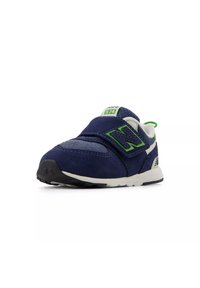 Baskets en suede bleu marine avec un accent vert, une sangle à boucle, une languette en mesh blanche et une semelle en caoutchouc noir présentant un motif texturé.