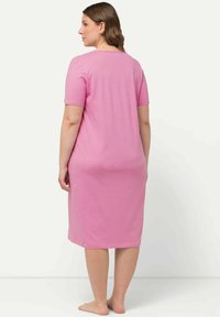 Abito rosa a maniche corte realizzato in tessuto morbido, lunghezza al ginocchio, con una vestibilità comoda e scollatura arrotondata, adatto per un abbigliamento casual.